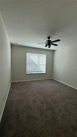 an empty room with a ceiling fan and a window
