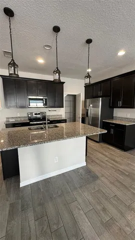 a large kitchen with kitchen island a sink stainless steel appliances and cabinets