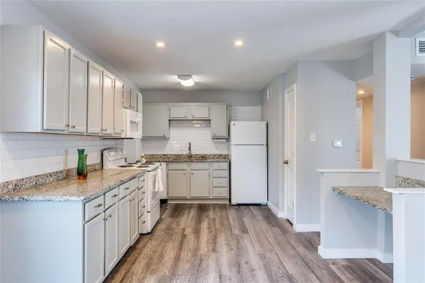 a kitchen with granite countertop cabinets stainless steel appliances a sink and a window