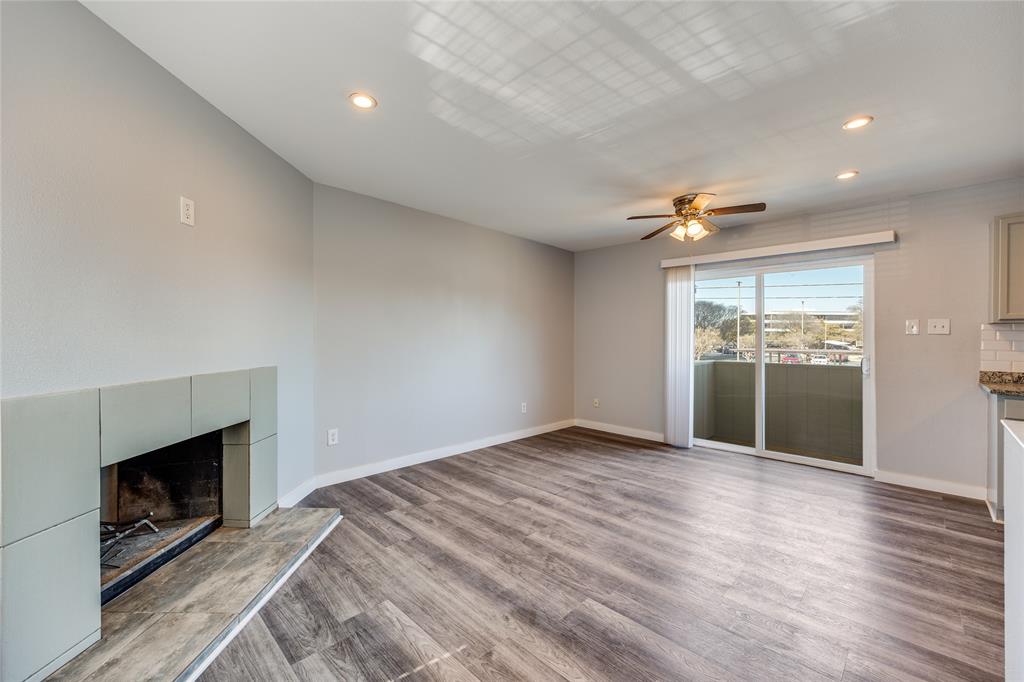 5725 Harvest Hill Road, Unit 2041 Dallas, TX 75230 - Photo 2 of 12 Unfurnished living room with a ceiling fan, recessed lighting, wood finished floors, and a tiled fireplace