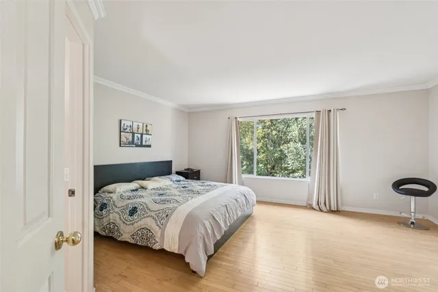 a bedroom with a bed and wooden floor