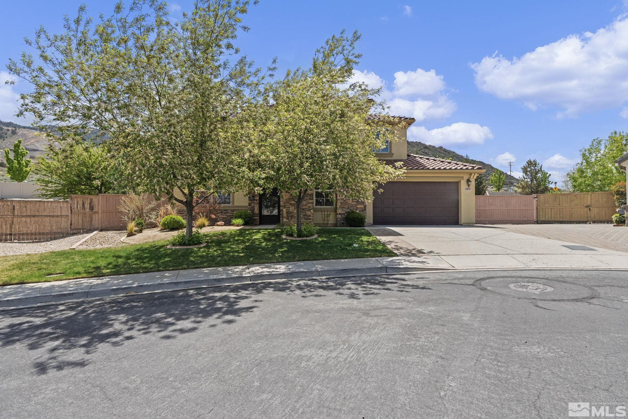 a front view of a house with a yard and trees