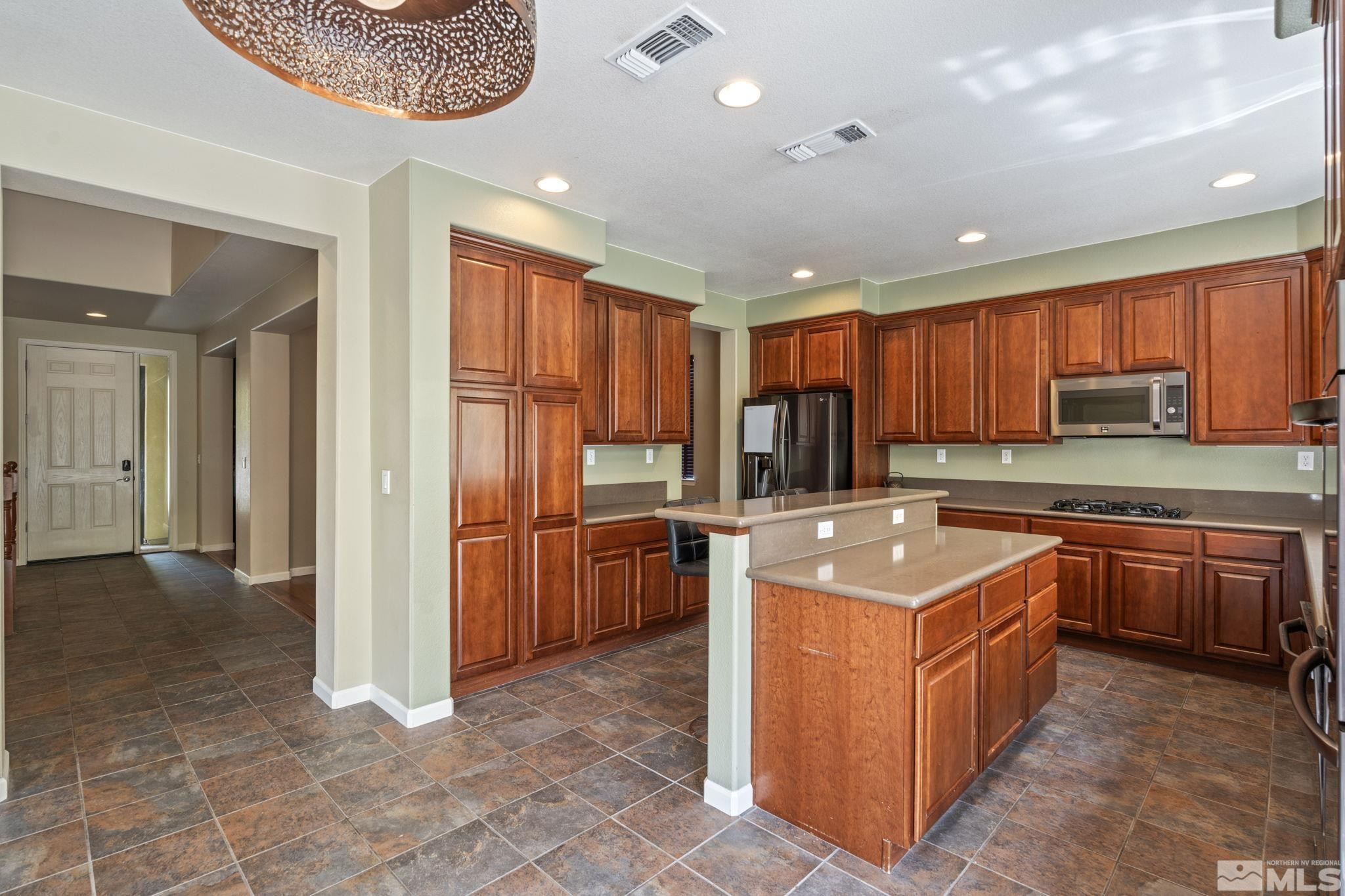 10890 Sand Hollow Court Reno, NV 89521 - Photo 12 of 40 a kitchen with stainless steel appliances granite countertop a stove top oven a refrigerator a sink and dishwasher