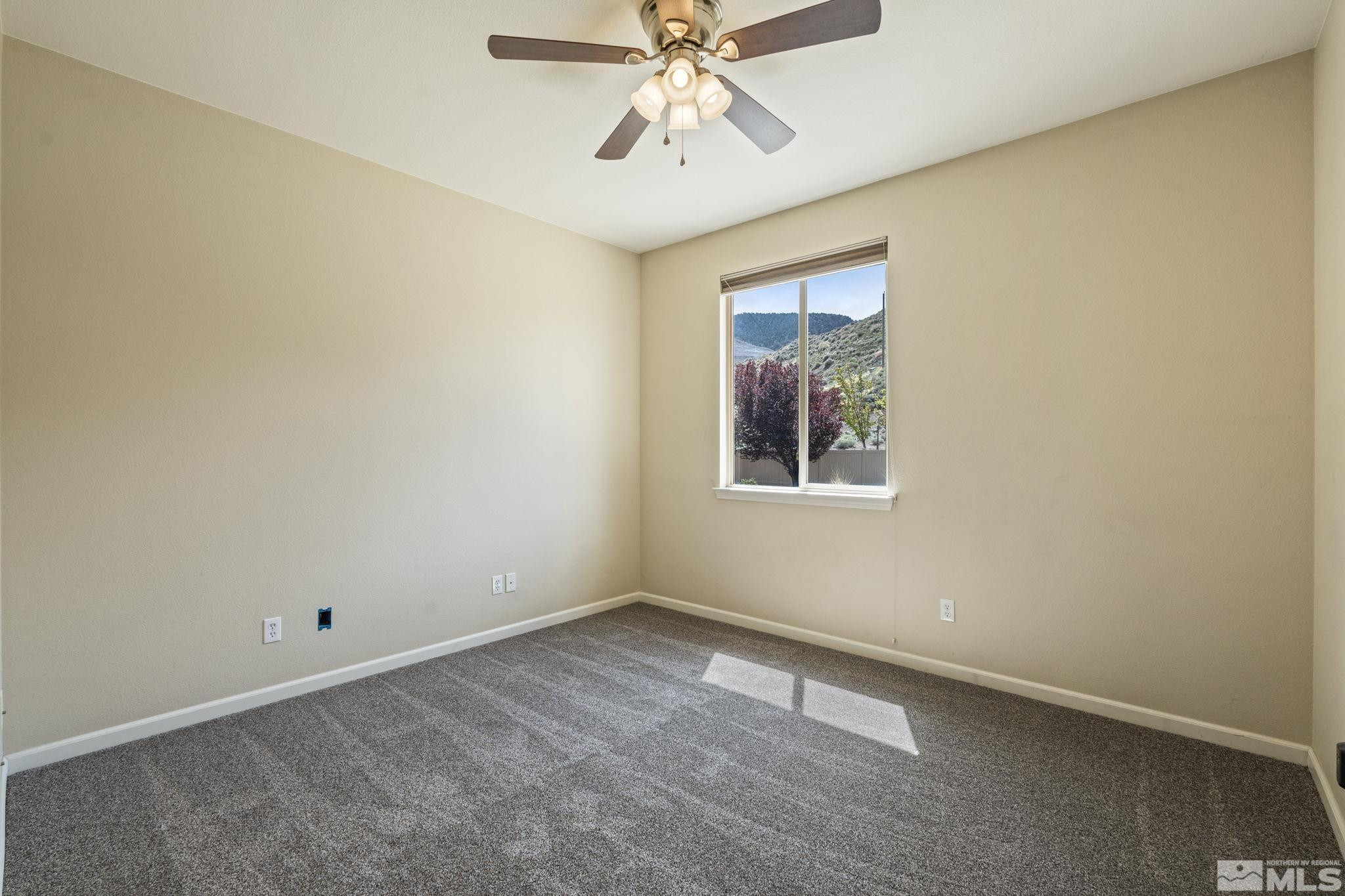 10890 Sand Hollow Court Reno, NV 89521 - Photo 25 of 40 an empty room with chandelier fan and windows
