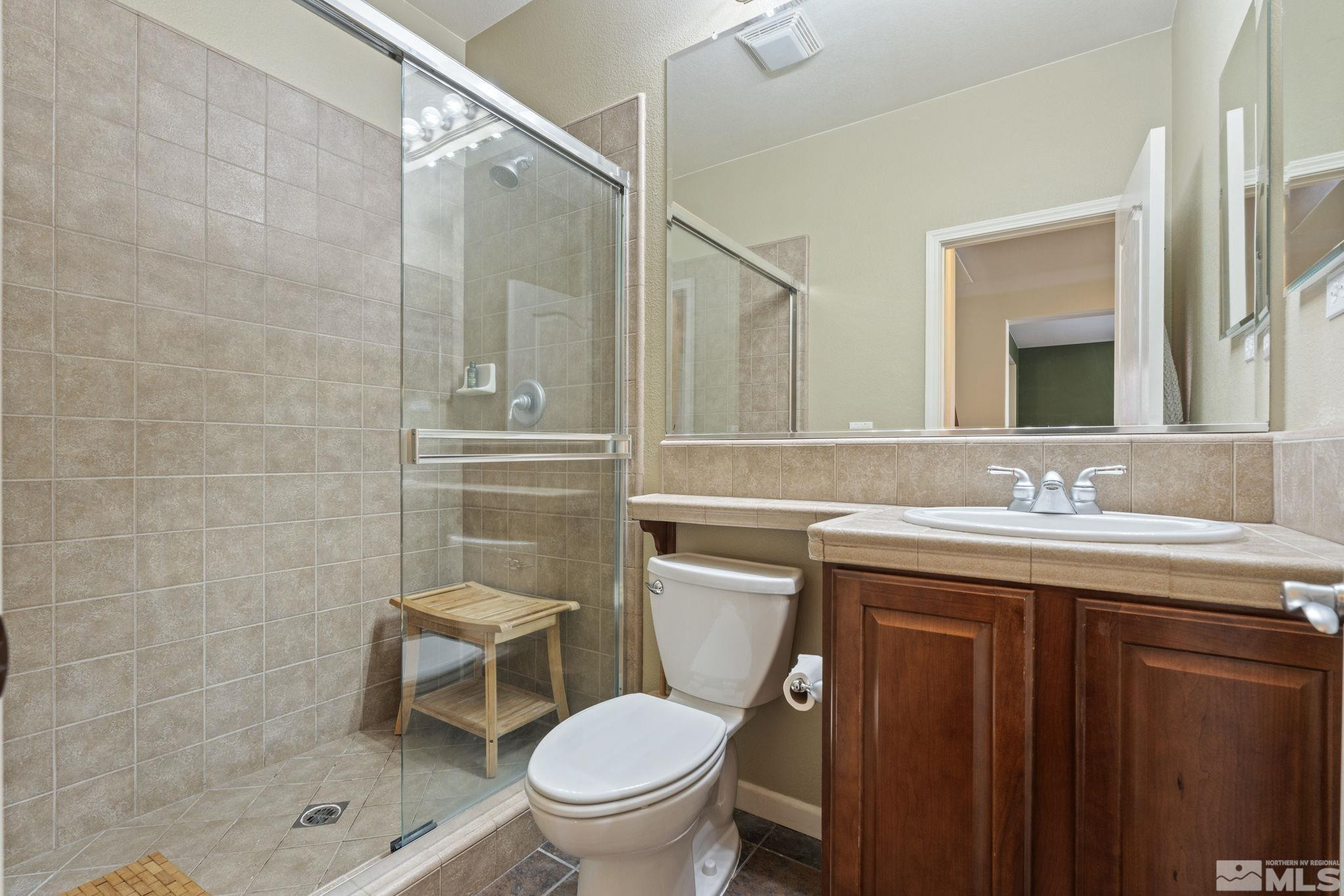 10890 Sand Hollow Court Reno, NV 89521 - Photo 28 of 40 a bathroom with a toilet sink vanity and mirror