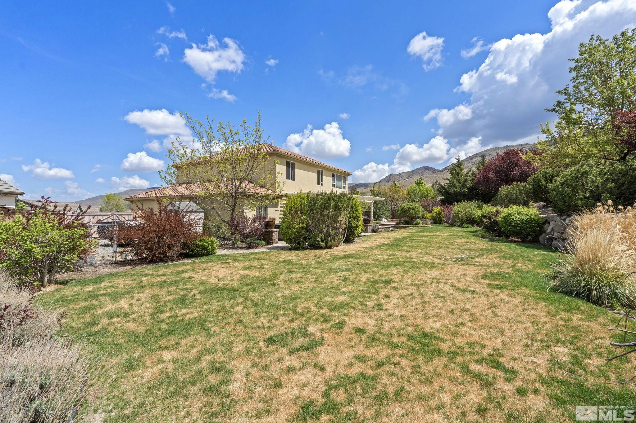 10890 Sand Hollow Court Reno, NV 89521 - Photo 33 of 40 a view of a big yard with large tree and wooden fence