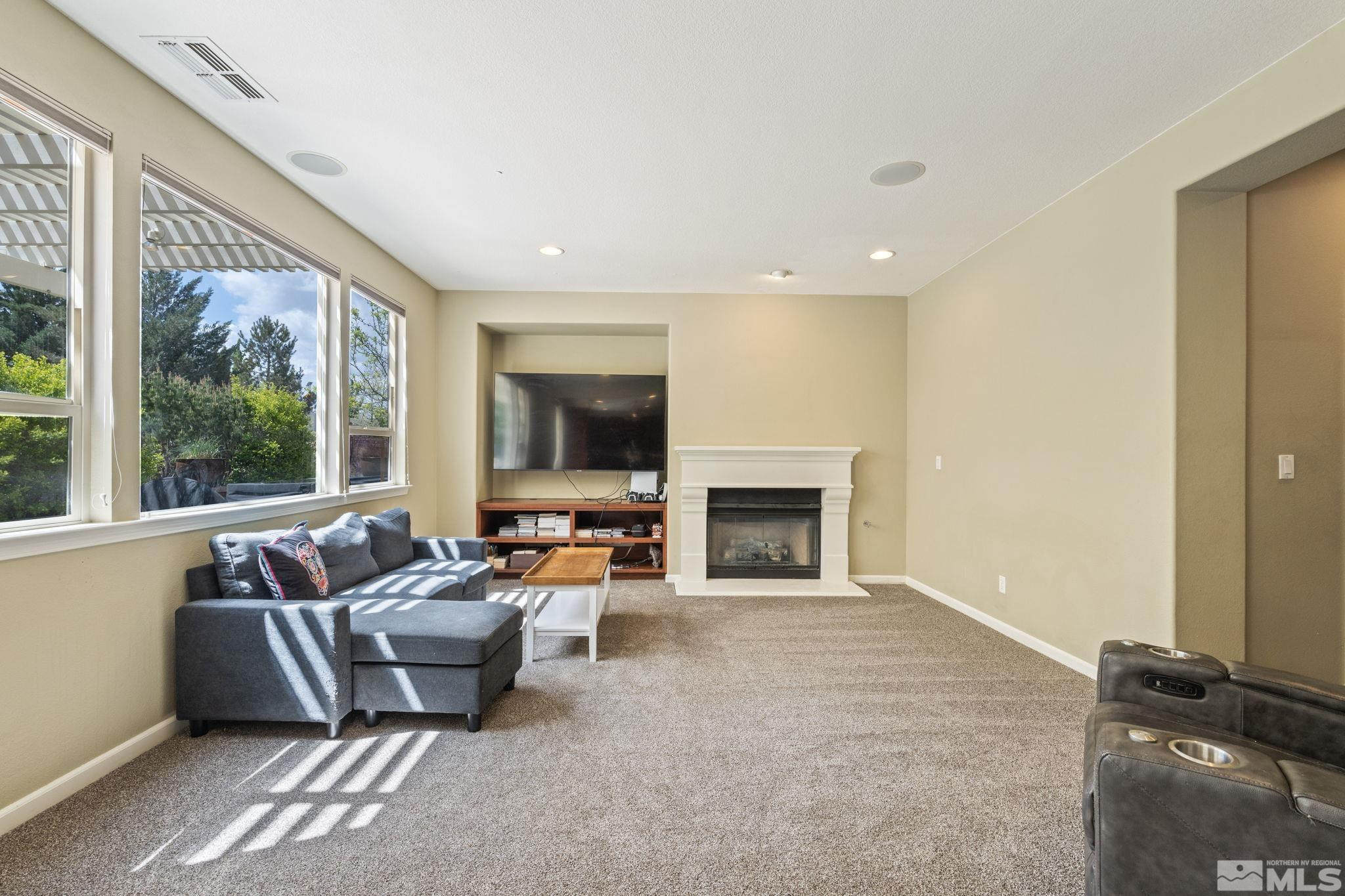 10890 Sand Hollow Court Reno, NV 89521 - Photo 4 of 40 a living room with furniture a fireplace and a flat screen tv