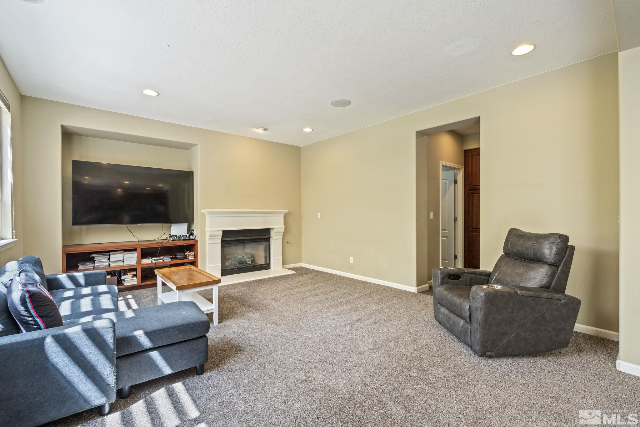 10890 Sand Hollow Court Reno, NV 89521 - Photo 5 of 40 a living room with furniture a flat screen tv and a fireplace