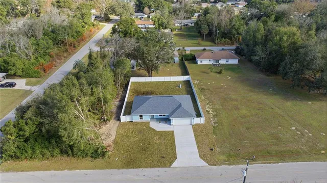 an aerial view of a residential houses with yard