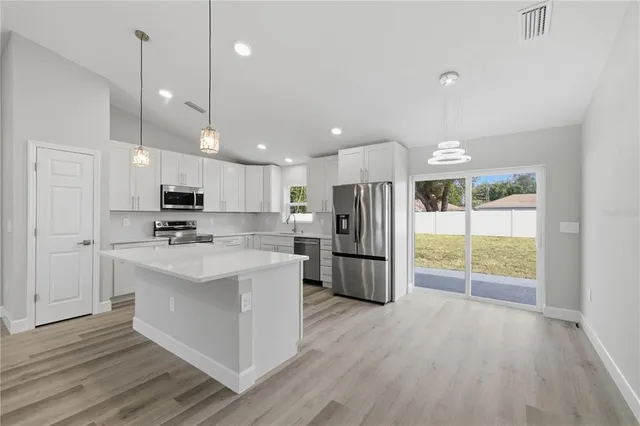 a kitchen with stainless steel appliances a refrigerator sink and microwave