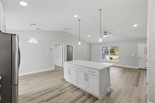 a kitchen with a refrigerator a sink and wooden floor