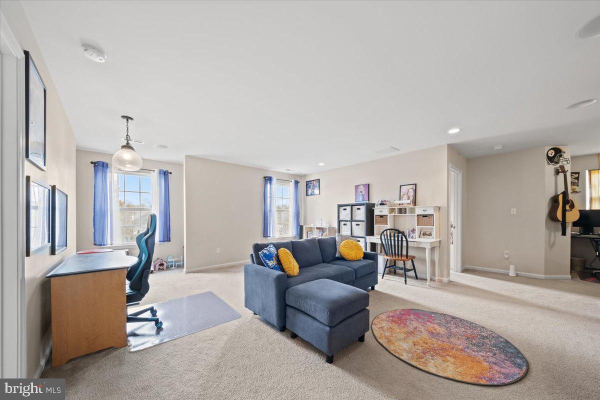 61 Homestead Drive Pemberton, NJ 08068 - Photo 16 of 40 a living room with furniture a dining table and a chandelier