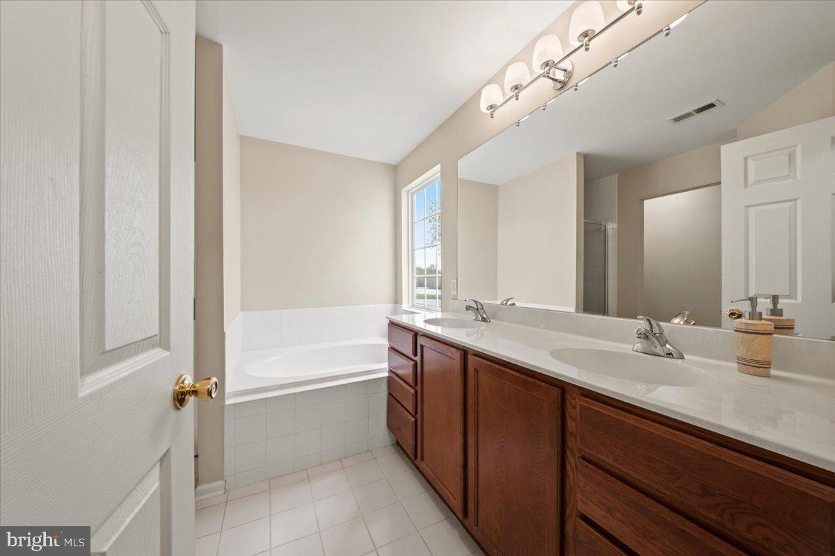 61 Homestead Drive Pemberton, NJ 08068 - Photo 27 of 40 a bathroom with a double vanity sink a mirror and a bathtub