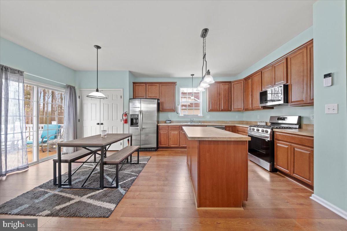61 Homestead Drive Pemberton, NJ 08068 - Photo 6 of 40 a large kitchen with stainless steel appliances granite countertop a stove a sink dishwasher a dining table and chairs with wooden floor