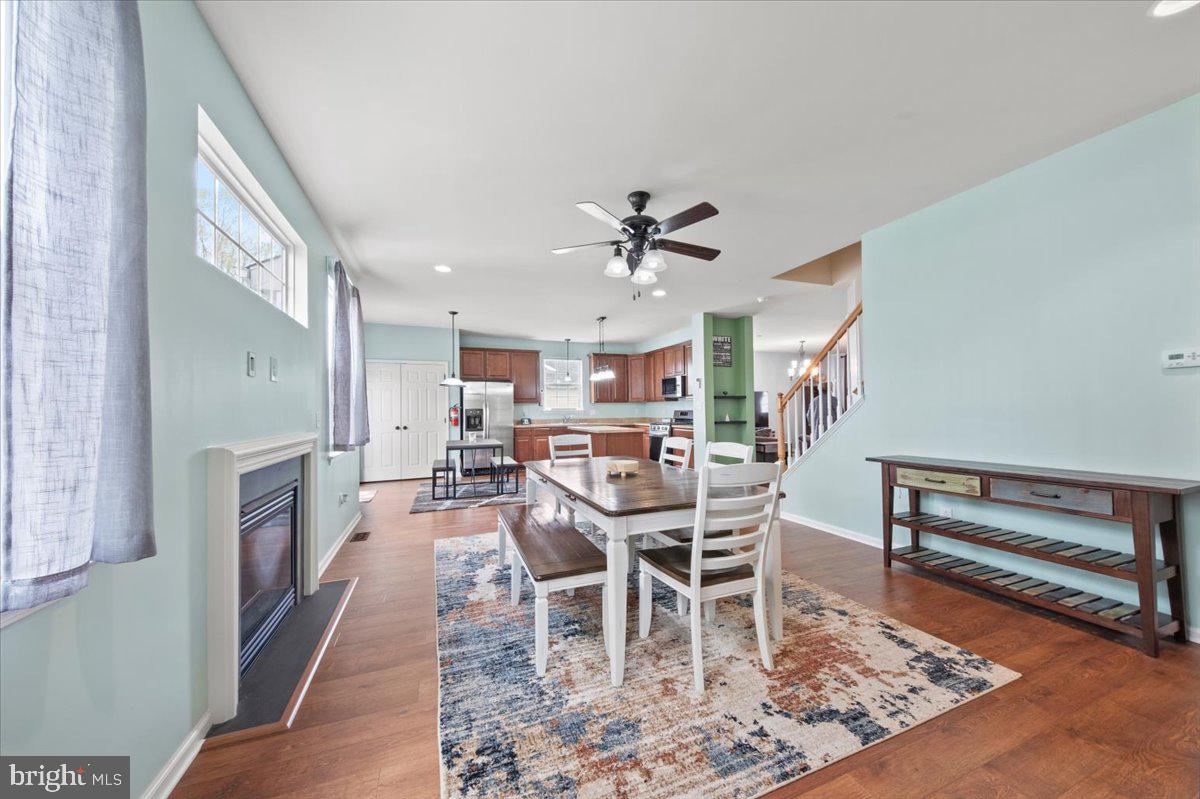 61 Homestead Drive Pemberton, NJ 08068 - Photo 10 of 40 a view of a dining room and livingroom with furniture a rug a fireplace and a painting