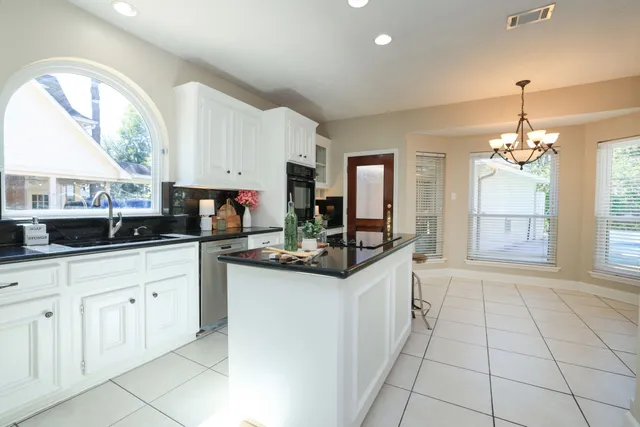 a kitchen with granite countertop a sink and cabinets