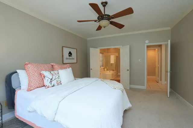 a spacious bedroom with a bed and a ceiling fan