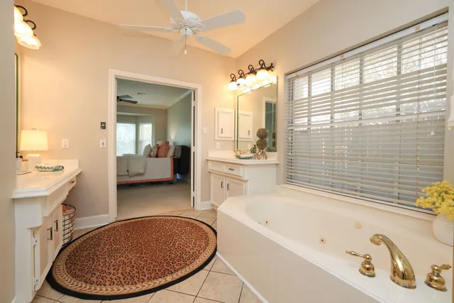 a bathroom with a tub a sink and a mirror