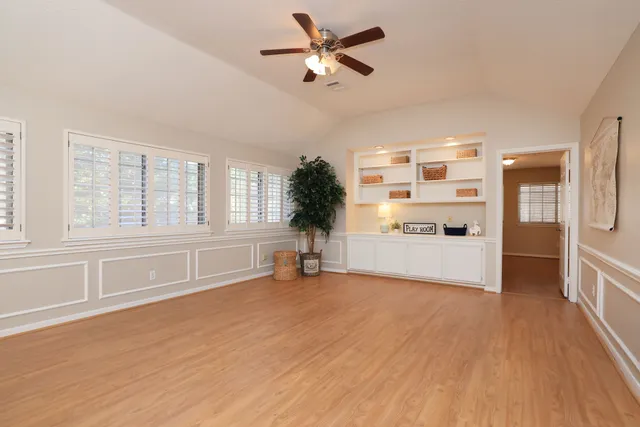 a view of a kitchen with furniture a ceiling fan and wooden floor