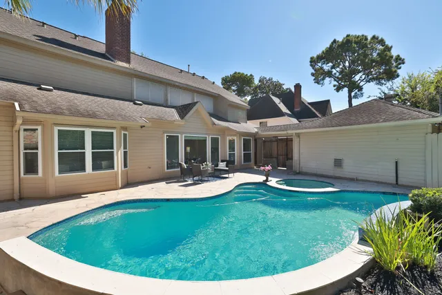a view of a house with backyard sitting area and garden