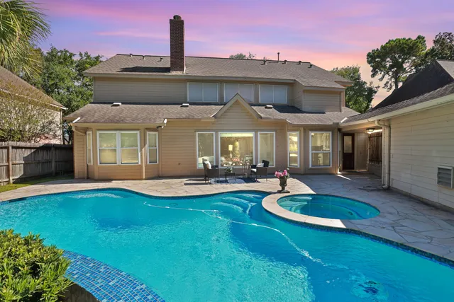 a front view of a house with swimming pool having outdoor seating