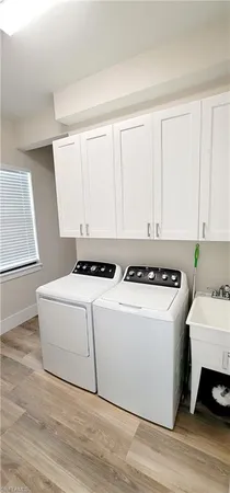 an empty room with wooden floor chandelier fan and window