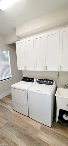 an empty room with wooden floor chandelier fan and window