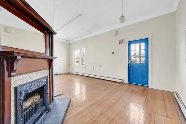 a view of a big room with wooden floor and windows