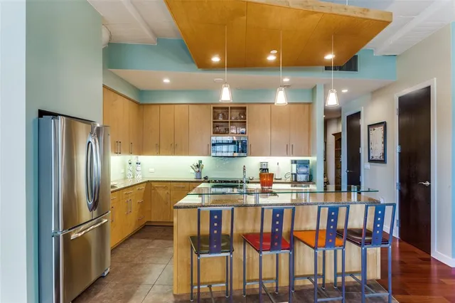 a kitchen with stainless steel appliances granite countertop a dining table and chairs