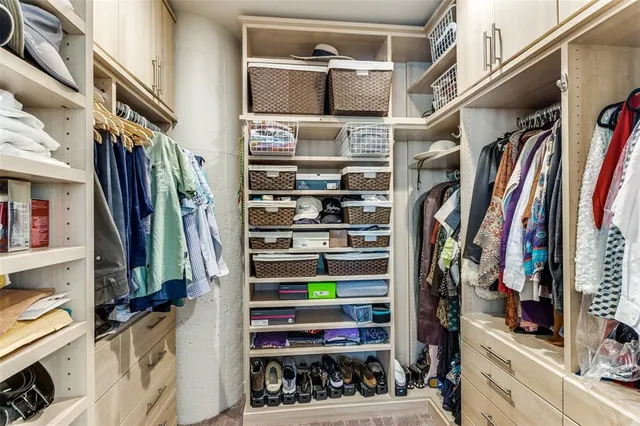 a view of walk in closet with clothes and shoes