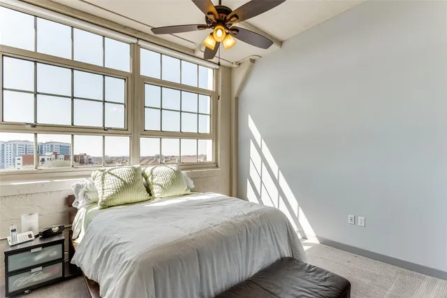 a bedroom with a bed and a large window