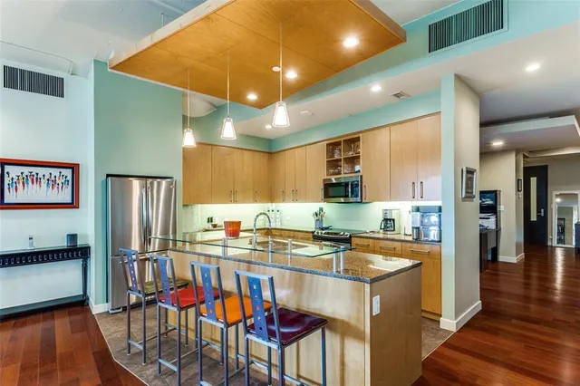 a kitchen with stainless steel appliances kitchen island granite countertop a sink and cabinets