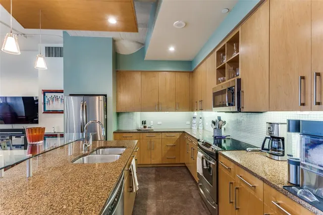 a kitchen with stainless steel appliances granite countertop a sink stove and refrigerator