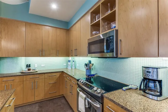 a kitchen with stainless steel appliances granite countertop a sink stove and cabinets