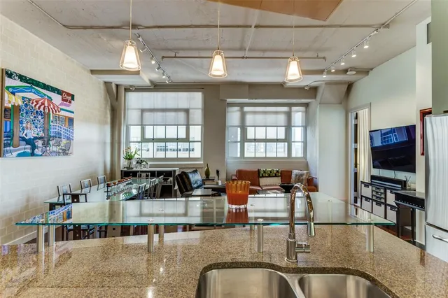 a kitchen with kitchen island granite countertop a large counter space dining table and stainless steel appliances