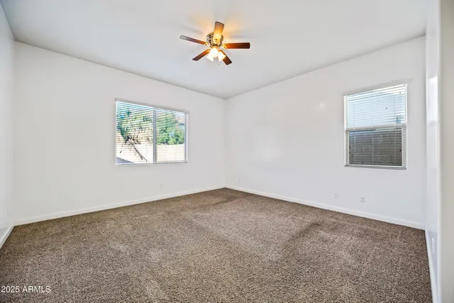 an empty room with a window and a ceiling fan