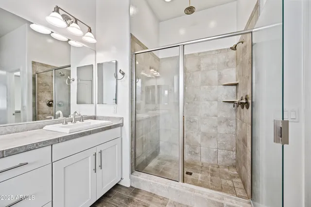 a bathroom with a shower sink and mirror