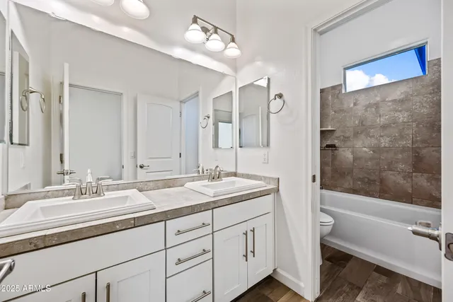 a bathroom with a double vanity sink mirror double and bathtub