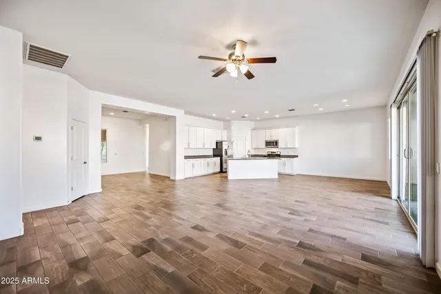 a view of an empty room and kitchen view