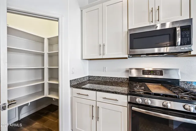a kitchen with stainless steel appliances a stove a microwave and sink