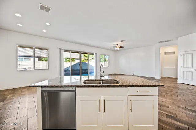 a kitchen with granite countertop a sink and white cabinets