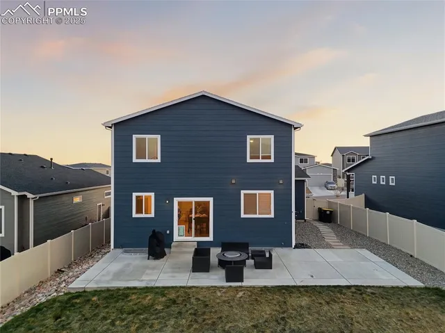 a backyard of a house with barbeque oven and outdoor seating