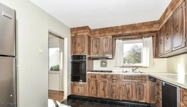 a kitchen with stainless steel appliances a sink and a refrigerator