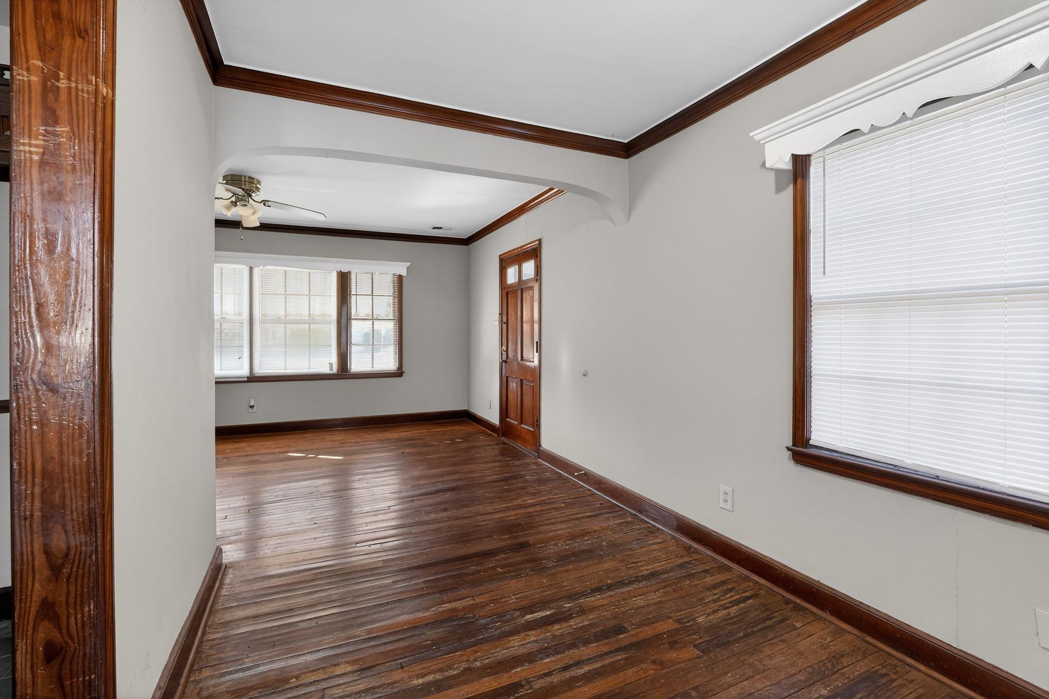 1068 Mt Vernon Road Memphis, TN 38111 - Photo 13 of 31 Spare room featuring dark wood-type flooring, ornamental molding, arched walkways, and a ceiling fan
