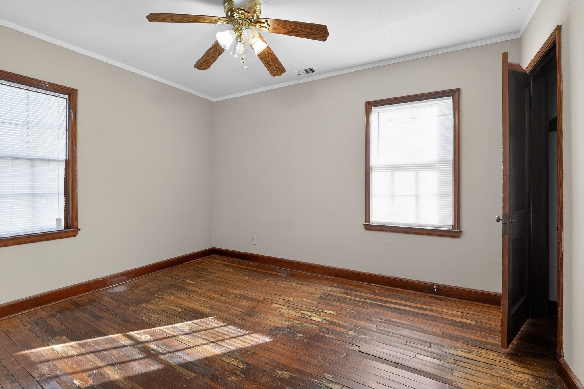 1068 Mt Vernon Road Memphis, TN 38111 - Photo 16 of 31 Empty room featuring dark wood-style floors, crown molding, and ceiling fan