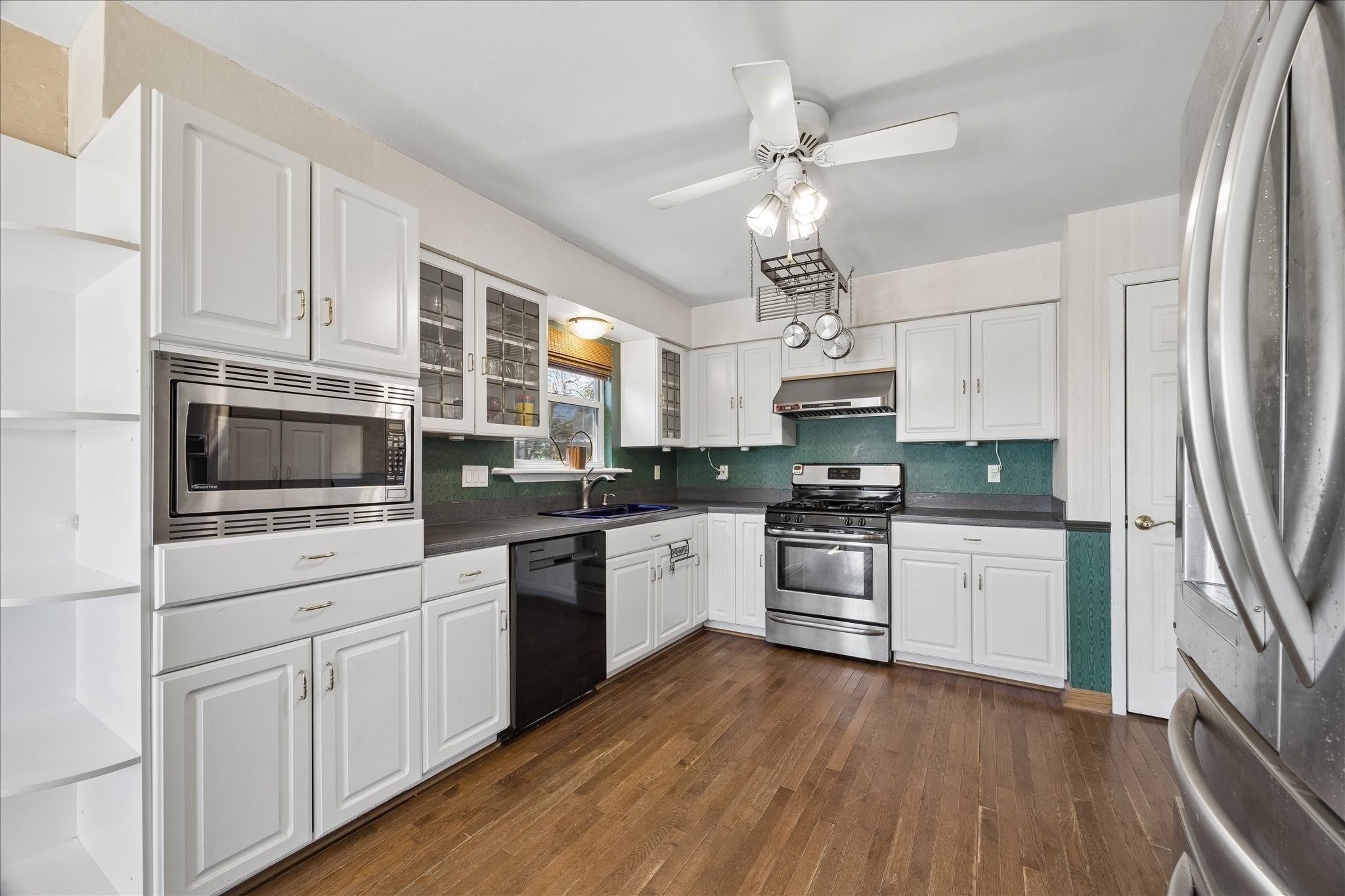1009 3rd Street Seabrook, TX 77586 - Photo 5 of 20 a kitchen with cabinets wooden floor and stainless steel appliances