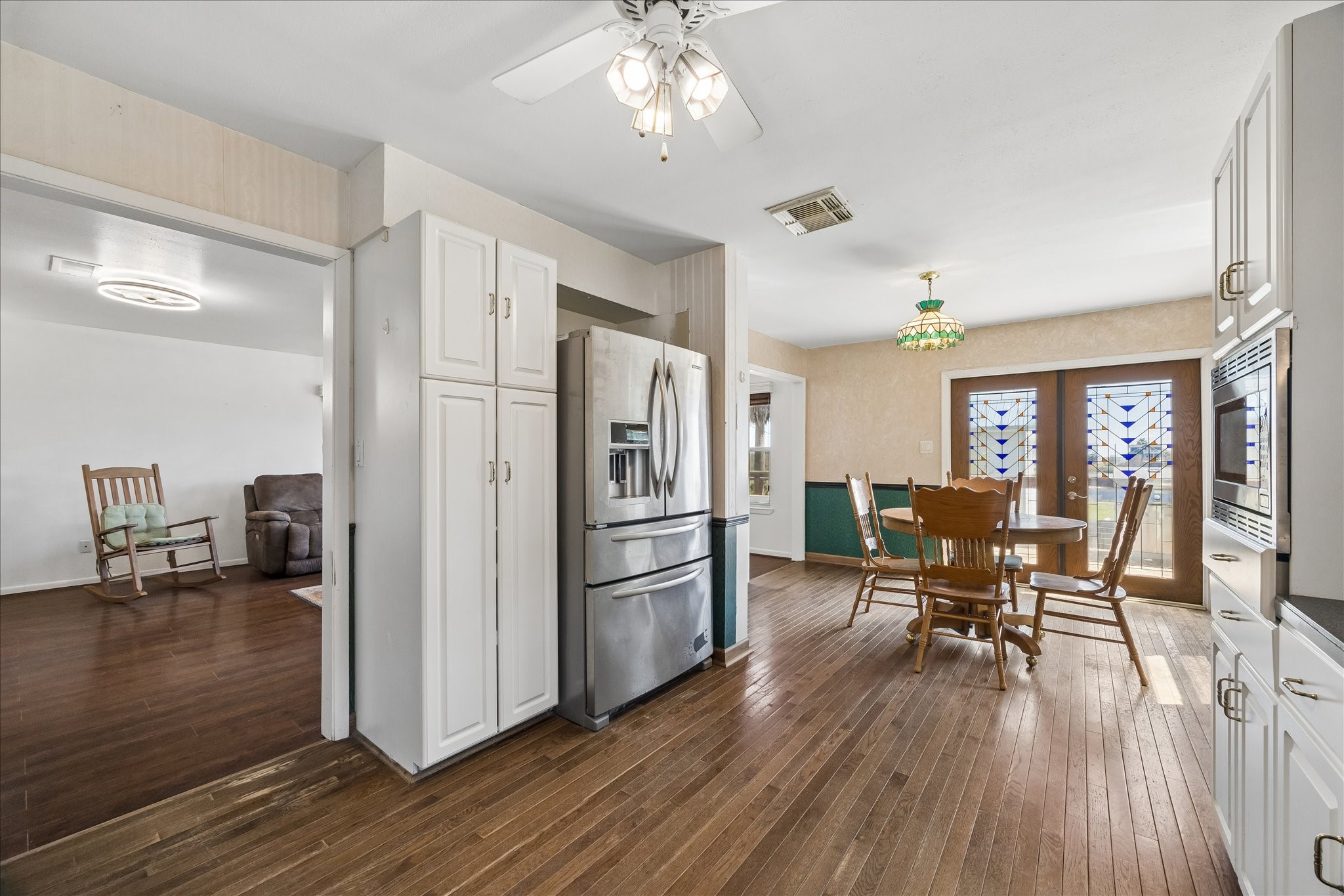 1009 3rd Street Seabrook, TX 77586 - Photo 6 of 20 a kitchen with stainless steel appliances a dining table chairs refrigerator and cabinets
