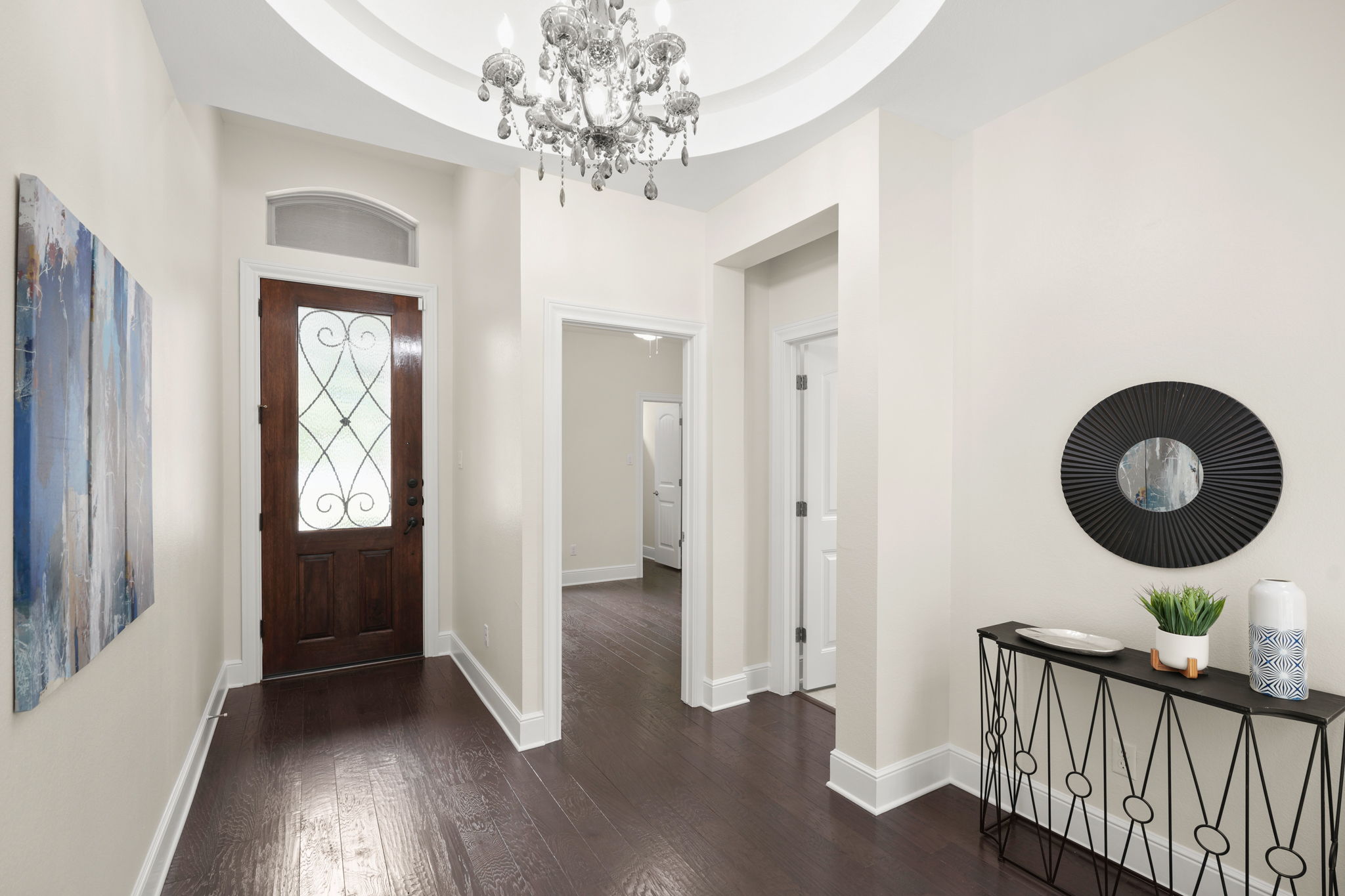 440 Cherokee Rose Circle Georgetown, TX 78626 - Photo 2 of 39 A grand entrance with rich hardwood flooring and a dazzling chandelier, setting a luxurious tone.