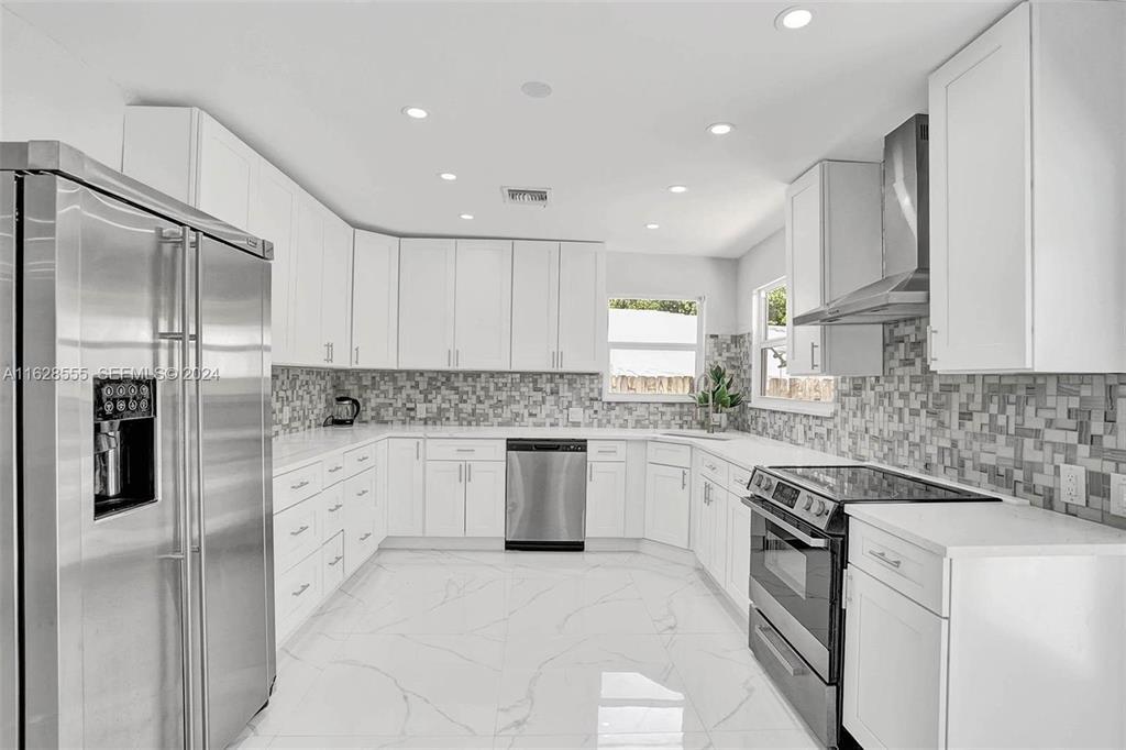 3421 Dover Road Pompano Beach, FL 33062 - Photo 7 of 22 a kitchen with granite countertop white cabinets and stainless steel appliances