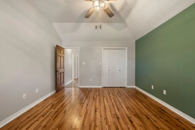 a view of a room with wooden floor and a ceiling fan